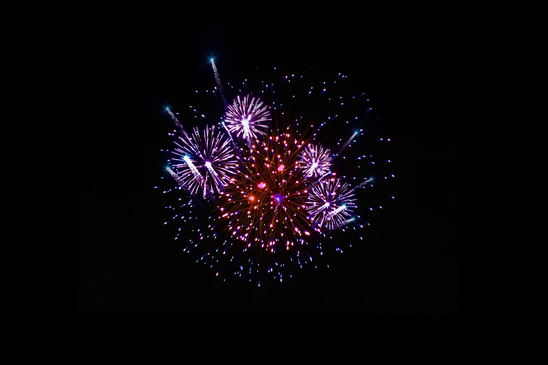 Spectacle pyrotechnique nocturne avec feux d'artifice multicolores explosant dans le ciel noir
